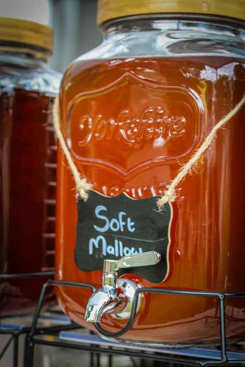 Large glass jug of brewed soft mallow tea with chalk label
